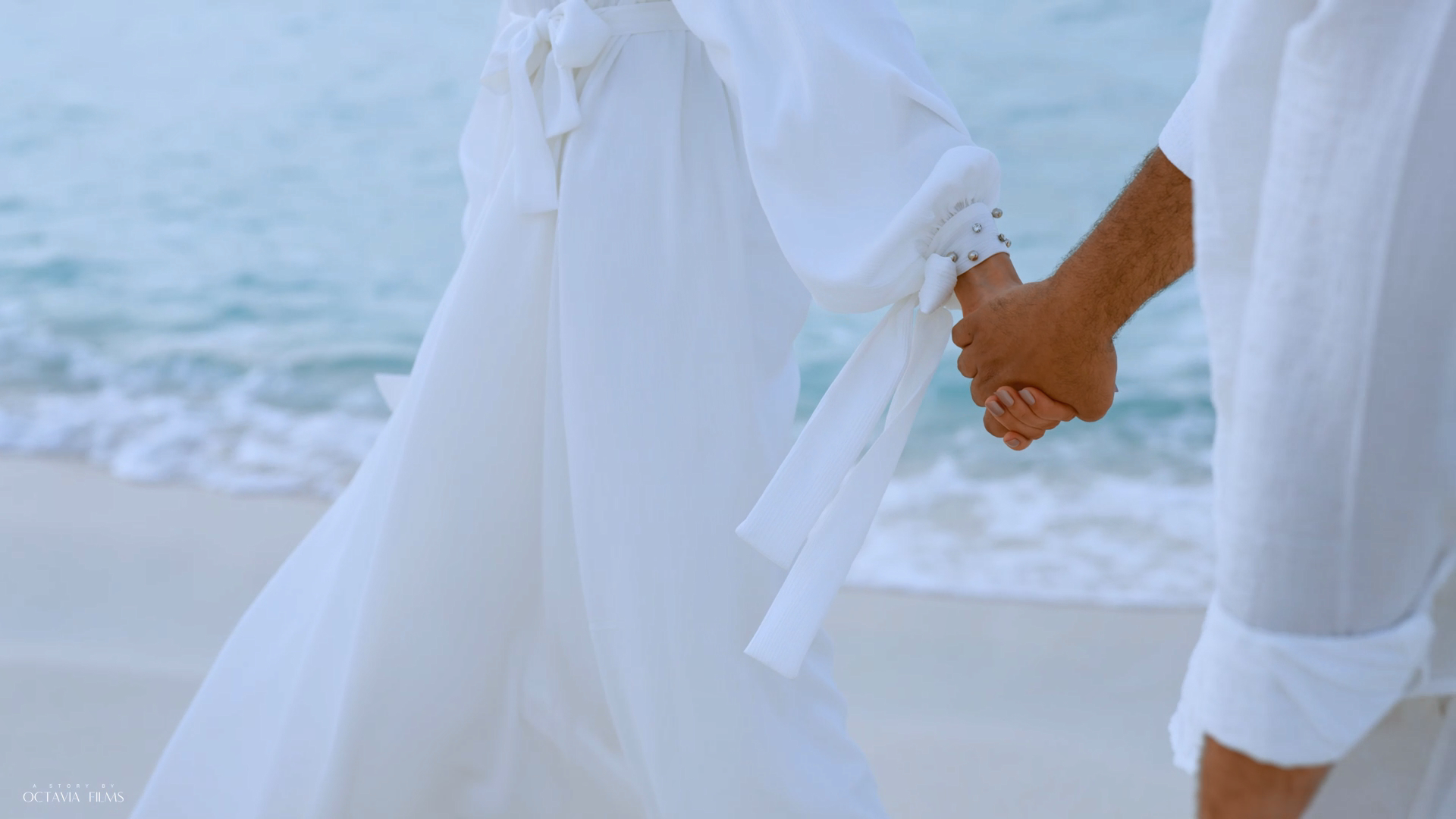 Bride and groom holding hands on the beach — photograph by Mostafa Alarian